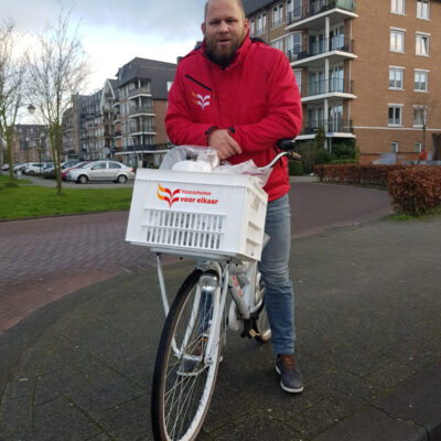 Jongerenwerker op de fiets met oliebollen